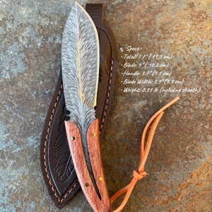 May include: A handcrafted knife with a feather-like blade design, wooden handle, and leather sheath. The blade is 4 inches (10.2 cm) long, and the total length is 7.7 inches (19.5 cm). The handle is 3.7 inches (9.4 cm) long. The knife weighs 0.31 lb (including sheath).