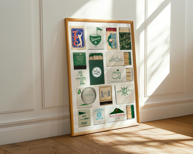 May include: A framed collection of vintage matchbooks, primarily green and white, with golf-themed designs and text. The frame is a light wood color, and the matchbooks are arranged in a grid pattern. The image is well-lit, with shadows adding depth.