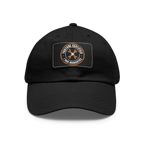 May include: Black baseball cap with a curved brim. The cap features a rectangular patch with the words "YOUTUBE CERTIFIED" and "I VOID WARRANTIES" in a circular design. The design includes crossed wrenches.