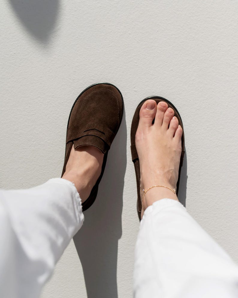 Comparison of a natural bare foot next to the wide toe box brown suede loafer, showing the healthy anatomical fit