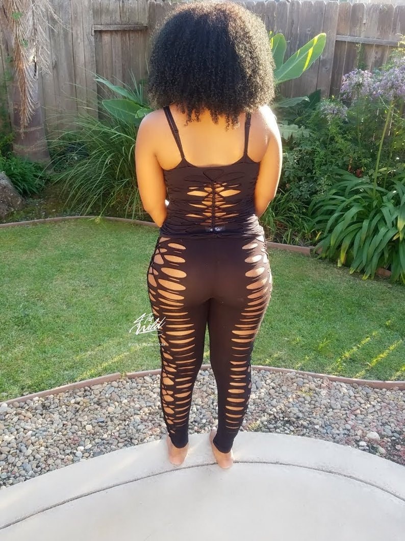Pode incluir: Leggings pretos com recortes e um top preto sem mangas com costas de renda.