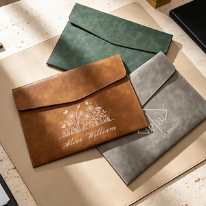 Op de afbeelding: Drie rechthoekige documentmappen in groen, bruin en grijs. De bruine map heeft een wit lijnontwerp van bloemen en de naam Alice William. De grijze map toont een geometrisch logo en de naam Patricia Barris in witte letters.