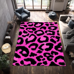 May include: A rectangular area rug with a vibrant pink background and bold black leopard spots. The rug is a statement piece, adding a pop of color and a wild pattern to a living space. The rug is made of a soft material.