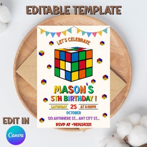 May include: A birthday party invitation featuring a colorful Rubik's Cube design. The invitation includes the text "Let's Celebrate" and "Mason's 5th Birthday!" with event details. The design is set on a wooden plate with an envelope.