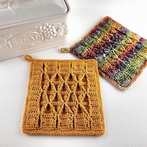 May include: Two crocheted pot holders, one in a mustard yellow colour with a diamond pattern and the other in a multi-coloured pattern with shades of red, orange, green, and purple.