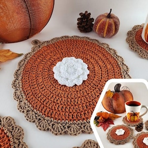 Può includere: Set di sottobicchieri all'uncinetto a forma di torta di zucca con un fiore all'uncinetto bianco al centro. I sottobicchieri sono marroni e arancioni e hanno un bordo smerlato. I sottobicchieri sono perfetti per aggiungere un tocco di arredamento autunnale alla tua casa.