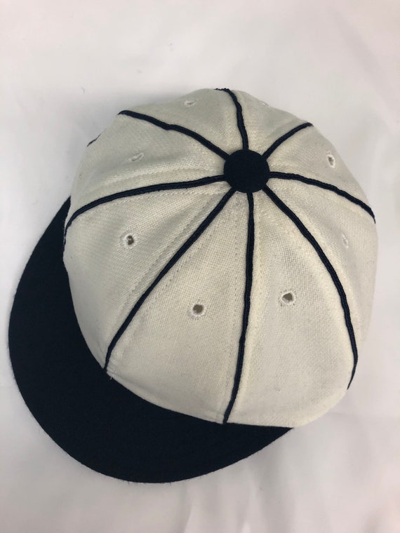 Detroit Vintage Base Ball 1859 Team cap. White wool flannel 8 panel with large black button, soutache, and short soft visor.