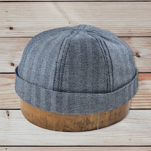 Docker 8 panel cap. Cotton denim in herringbone, hickory stripe or solid denim, folded cuff, fitted to any size.