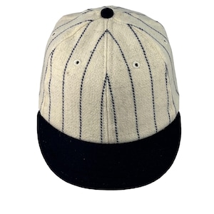 May include: A white baseball cap with black pinstripes and a black brim.