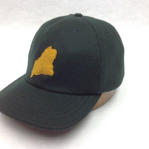 May include: A dark green baseball cap with a yellow felt outline of the state of Maine on the front.