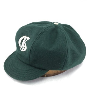 8 panel baggy cricket cap in dark green melton wool. Fitted to any size, old english embroidered logo, any letter available.