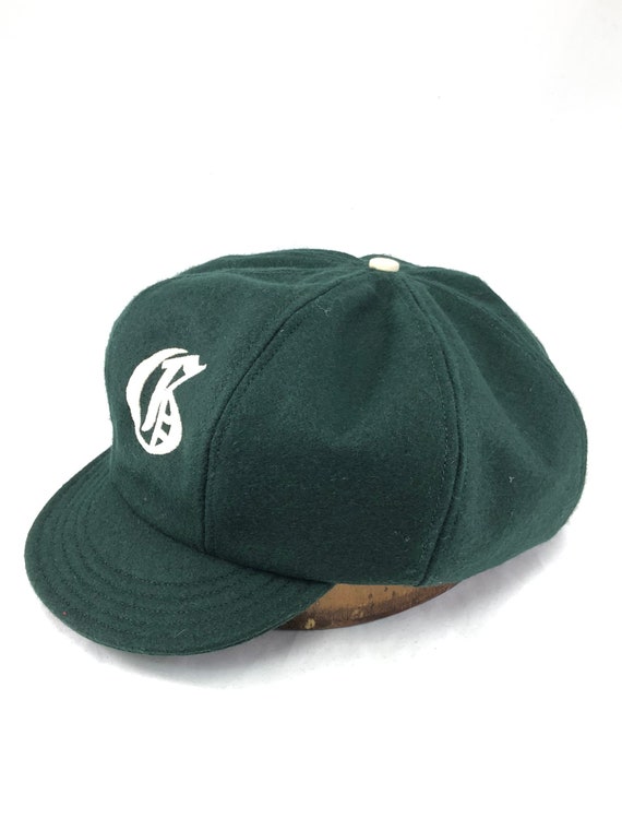 8 panel baggy cricket cap in dark green melton wool. Fitted to any size, old english embroidered logo, any letter available.