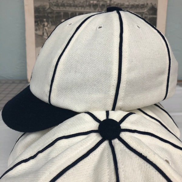 Detroit Vintage Base Ball 1859 Team cap. White wool flannel 8 panel with large black button, soutache, and short soft visor.