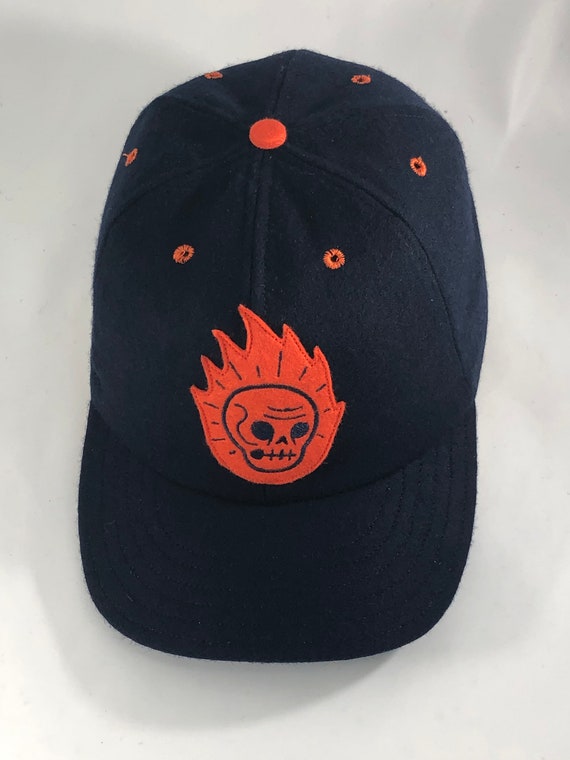 Flaming skull felt patch, art by Ryan Hungerford. Navy melton wool cap 6 panel with 2.5” visor. Any size available.