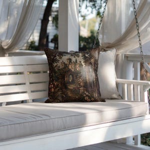 May include: A square throw pillow featuring a detailed tapestry-style print of a stone castle surrounded by lush gardens, trees, and flowers in shades of brown, green, and cream. The pillow is placed on a white wooden bench with a plain cream cushion.
