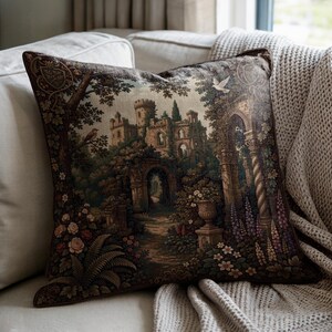 May include: A square throw pillow featuring a woven tapestry design of a stone castle ruin surrounded by lush trees, archways, and blooming flowers in shades of brown, green, and purple. A white bird is visible in the upper right sky area.
