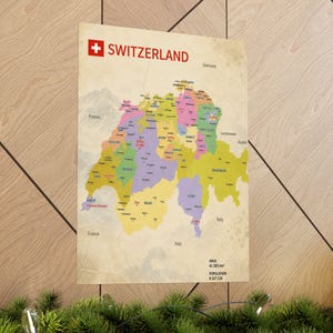 May include: A rectangular wall poster featuring a colorful map of Switzerland with the text SWITZERLAND at the top. The map displays cantons in various pastel shades, labeled cities, and surrounding countries. Bottom text reads AREA 41 285 km² and POPULATION 8 327 126.