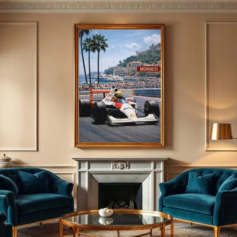 May include: Framed print of a Formula 1 race car speeding on a track. The car is white, red, and black, with the "Marlboro" logo visible. The background shows a coastal city with palm trees and a sign that reads "Monaco".