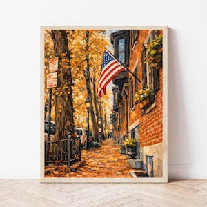 May include: A framed painting depicts a charming autumn street scene. The artwork showcases a brick building with an American flag, a tree-lined sidewalk covered in fallen leaves, and a wrought-iron fence. The color palette is dominated by warm tones of orange, brown, and red.