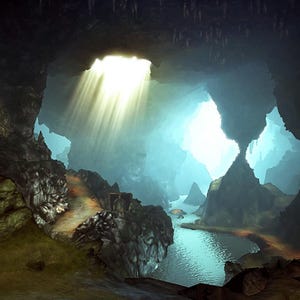 May include: A dark cavern interior featuring a natural rock opening that allows bright sunlight to stream down in rays. A small, glowing golden statue sits within a recessed rock niche, illuminated by a cluster of small white candles on the ground.