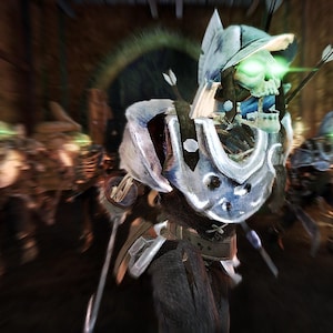 May include: A skeletal figure wearing silver metal armor and a helmet with glowing green eyes. The figure is equipped with a quiver of arrows on its back and is positioned in a dark, blurred environment with other similar skeletal figures nearby.