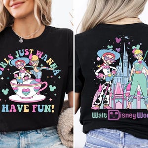 May include: Black t-shirt with a colourful graphic featuring two cartoon characters in a teacup with the text "GIRLS JUST WANNA HAVE FUN!" on the front. The back of the shirt has a matching design with the text "Walt Disney World".