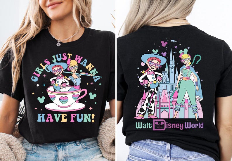 May include: Black t-shirt with a colourful graphic featuring two cartoon characters in a teacup with the text "GIRLS JUST WANNA HAVE FUN!" on the front. The back of the shirt has a matching design with the text "Walt Disney World".