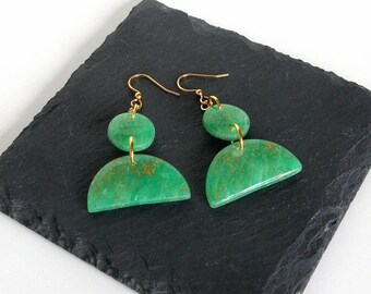 May include: A pair of green and gold earrings with a geometric design. The earrings are made of polymer clay and have a gold-tone finish.