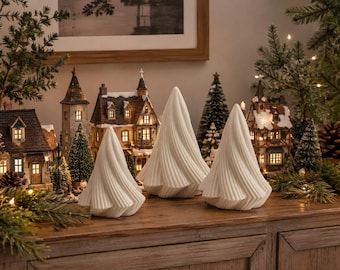 Op de afbeelding: Drie witte, abstracte, kegelvormige sculpturen met een spiraalvormige, geribbelde textuur. Deze gladde, effen gekleurde decoratieve objecten zijn in een groep gerangschikt, met een puntige bovenkant en een brede, uitlopende basis met een wervelend ontwerp.