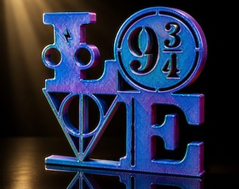 Op de afbeelding: Een 3D-geprint beeldhouwwerk dat het woord LOVE spelt in een verloop van blauw en paars. De letter L bevat een bliksemschicht, de O bevat het getal 9 3/4, de V toont een driehoekig symbool en de E is een massieve blokletter.