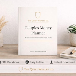 May include: A cream-colored book titled "Couples Money Planner" with gold text and a shield logo. The book is on a wooden surface with a small plant, glasses, and a pen. The text reads "A calm system for shared financial clarity."