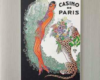 May include: Vintage art print with the text "CASINO DE PARIS", depicting a woman in an orange dress and a leopard holding flowers. The artwork has a black and white background with green accents and a decorative border.