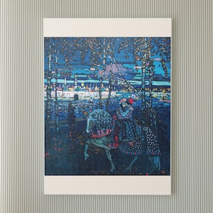 May include: A framed art print depicting a nighttime scene with a figure on horseback. The artwork features a dark blue and teal color palette, with birch trees and a distant cityscape. The rider wears a patterned dress and hat.