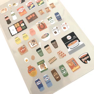 Könnte beinhalten: Ein Bogen mit bunten Aufklebern mit verschiedenen Lebensmitteln, darunter Snacks, Getränke und Fertiggerichte. Die Aufkleber zeigen eine Vielzahl von Designs, wie Ramen, Kaffeetassen und Limonaden. Der Bogen hat einen transparenten Hintergrund.