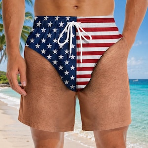 May include: Swim trunks featuring a split design with a blue field of white stars on the left and horizontal red and white stripes on the right. The garment includes a white drawstring at the elastic waistband and a solid tan lower section.
