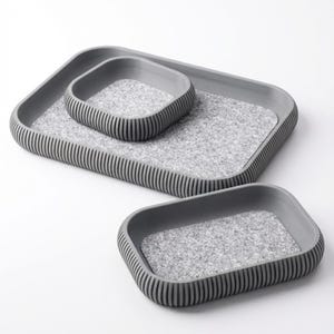 May include: A set of three gray trays with a textured, speckled interior. The trays are rectangular with rounded corners and ribbed sides. The smallest tray sits inside the medium tray, which sits inside the largest tray.