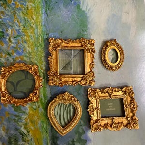 Puede incluir: Una colección de marcos de fotos dorados y ornamentados de varias formas, incluyendo redondos, cuadrados y en forma de corazón. Un marco contiene el texto "calm and confident". Los marcos están dispuestos sobre un fondo con un diseño abstracto colorido.