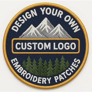 Op de afbeelding: Ronde geborduurde patch met een marineblauwe achtergrond en een gouden rand. De patch toont een bergketen met witte toppen, groene bomen en de tekst "DESIGN YOUR OWN CUSTOM LOGO EMBROIDERY PATCHES" in het wit.