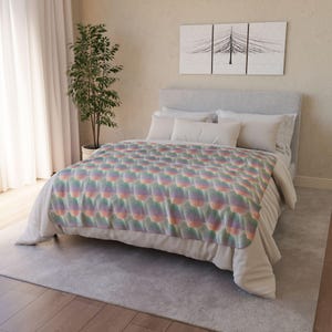 May include: A bed with a pastel-colored blanket. The blanket has a repeating pattern of rounded shapes in shades of pink, green, and orange. The bed has white bedding and pillows. A plant and artwork are in the background.