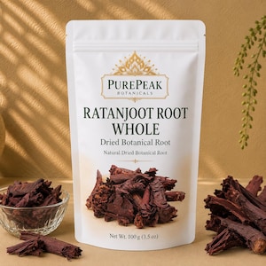 Peut inclure: Un sachet blanc debout étiqueté PurePeak Botanicals Ratanjoot Root Whole, contenant des racines botaniques séchées. L'étiquette indique un poids net de 100 g. Des morceaux de racines ligneuses brun rougeâtre foncé sont visibles sur le sachet.