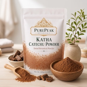 May include: A white stand-up pouch labelled PurePeak Botanicals Katha Catechu Powder, containing 100 g of dried botanical powder. The pouch features brown decorative patterns, accompanied by a wooden scoop and bowls of brown powder.