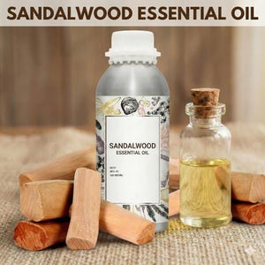 May include: A silver metal bottle of sandalwood essential oil with a white cap, a small glass bottle with a cork, and several pieces of sandalwood. The label on the bottle reads "Sandalwood Essential Oil."