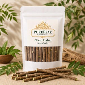 Op de afbeelding: Een witte stazak met bruine neemstokjes, gelabeld PurePeak Botanicals Neem Datun Neem Sticks. De zak heeft een doorzichtig venster dat de houten stokjes binnenin toont, met extra stokjes gerangschikt in een hoopje voor de zak.