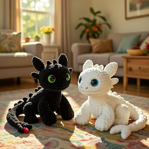 May include: Two crocheted dragon plushies, one black with green eyes and the other white with blue eyes, are displayed on a patterned rug. The dragons have detailed features and are posed in a playful manner.