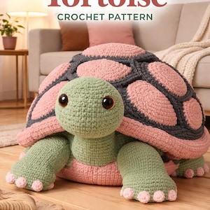 May include: A large, handmade amigurumi tortoise in soft green, pink, and gray yarn. The tortoise has a textured shell, large eyes, and detailed feet. The image includes the text "Amigurumi Tortoise CROCHET PATTERN" and icons for PDF pattern and instant download.