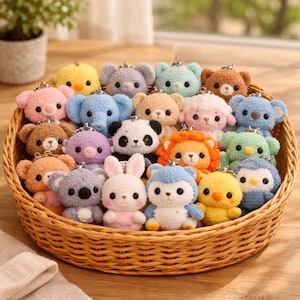 Puede incluir: Una cesta de mimbre llena de una variedad de llaveros de animales de ganchillo coloridos. La colección incluye osos, elefantes, pandas, leones, koalas, conejos y pingüinos, cada uno con un diseño y expresión únicos.