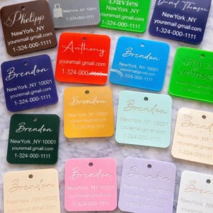 Può includere: Una collezione di etichette quadrate in acrilico colorato con angoli arrotondati. Ogni etichetta presenta un nome e informazioni di contatto in un colore a contrasto. Le etichette sono in vari colori, tra cui verde, blu, rosso e rosa.