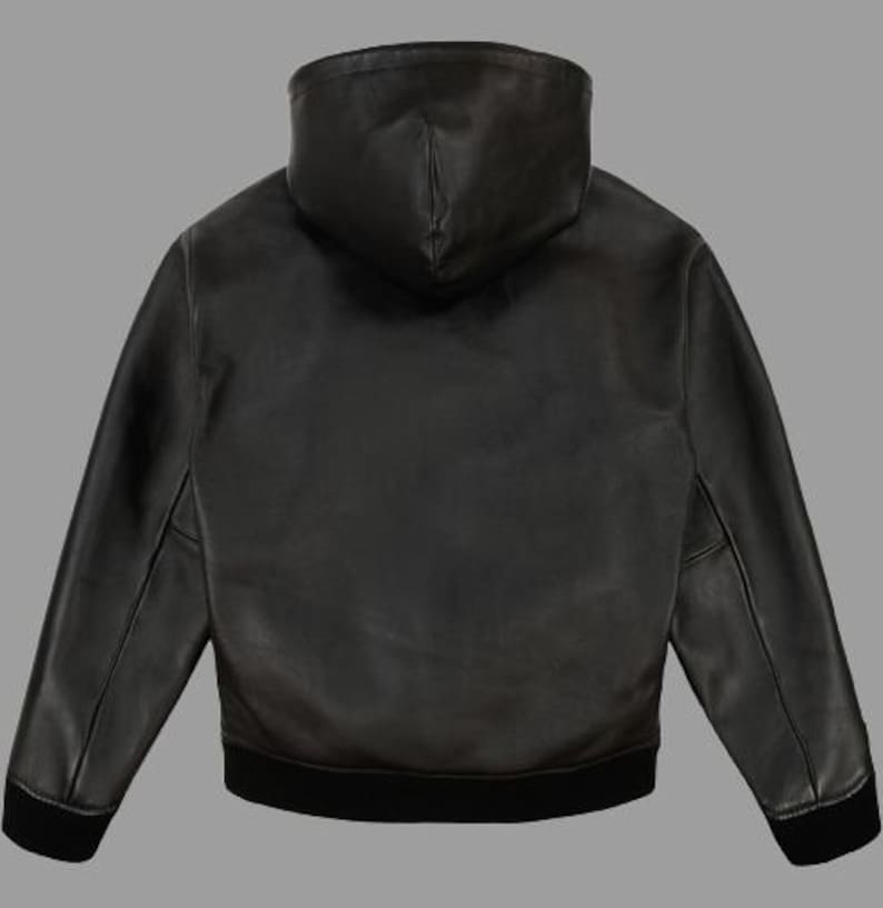 K&ouml;nnte beinhalten: Schwarze Lederjacke mit Kapuze, geripptem Saum und B&uuml;ndchen. Die Jacke hat einen durchgehenden Rei&szlig;verschluss und eine Kapuze. Die R&uuml;ckansicht zeigt die glatte Lederstruktur und das ma&szlig;geschneiderte Design. Ein klassisches Oberbekleidungsst&uuml;ck.