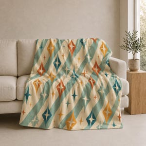 Peut inclure: Une couverture à motifs drapée sur un canapé beige. La couverture présente un design rétro avec des rayures diagonales turquoise et des formes de diamants orange, jaune et bleu. Un élément de décoration intérieure confortable.