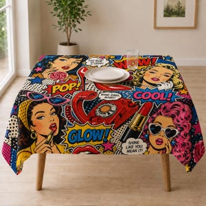 May include: A square tablecloth featuring a vibrant pop art comic book print with illustrations of women, a red rotary telephone, lipstick, and high heels. Text bubbles include "TOO GLAM TO GIVE A DAMN!", "POP!", "RING RING, BABY!", "COOL!", "GLOW!", and "SHINE LIKE YOU MEAN IT!"